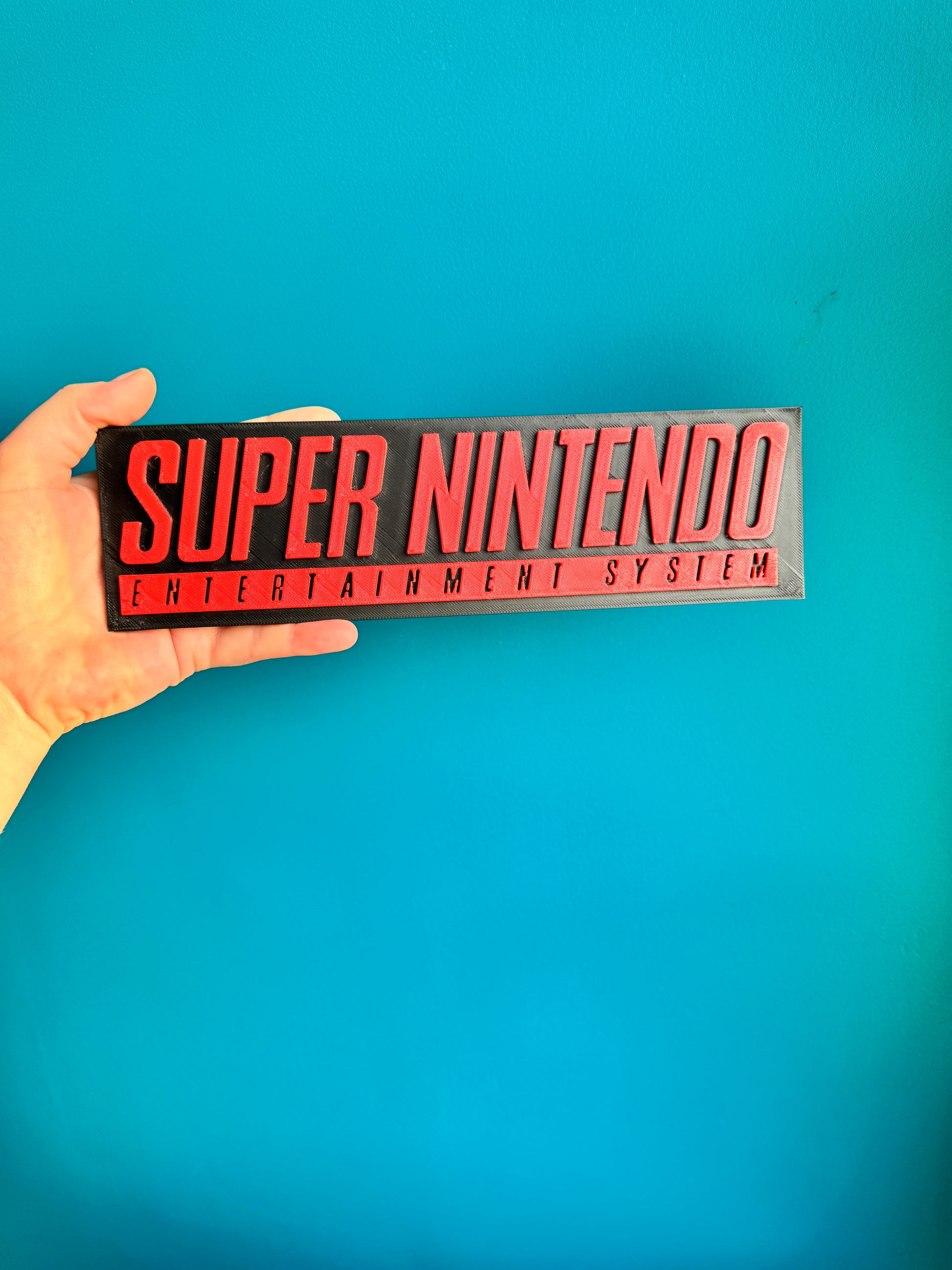 Plaque murale Super Nintendo imprimée en 3D, rouge et noir, format 24 cm.


